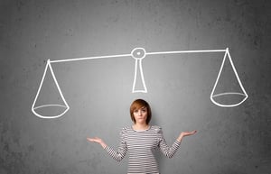 Pretty young lady taking a decision with scale above her head